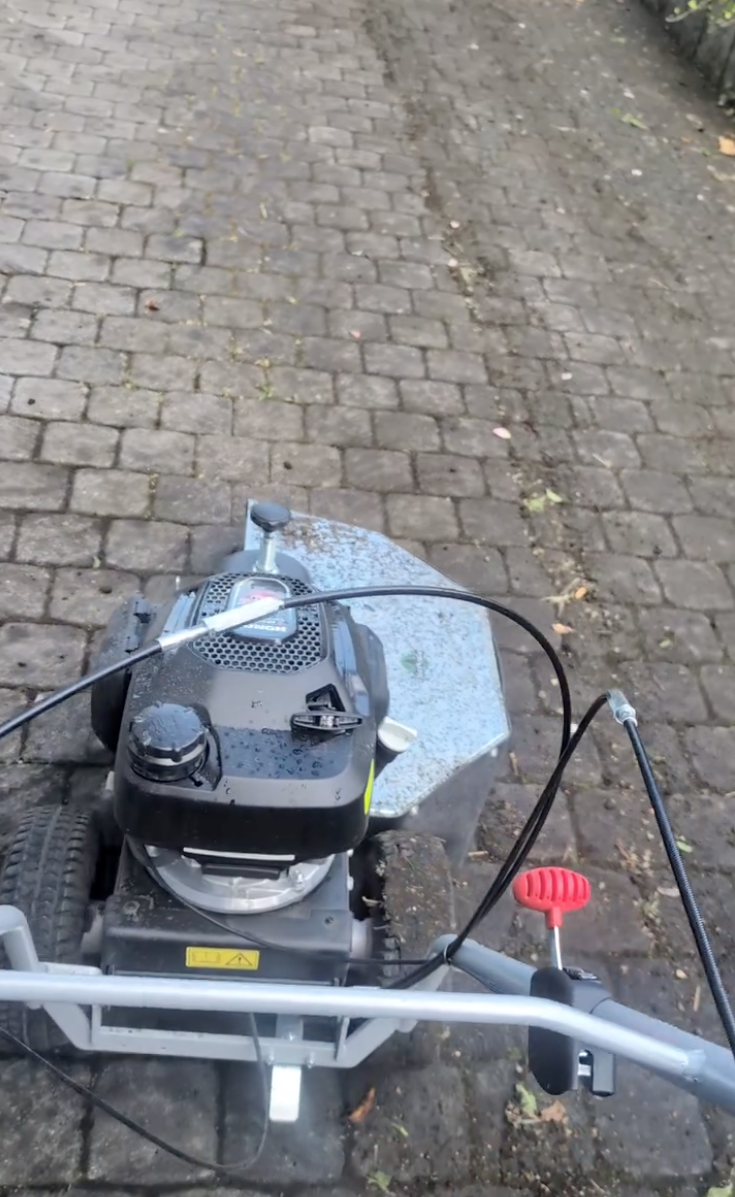 Motorisierte Reinigungsmaschine im Einsatz auf Pflastersteinen